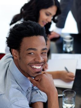 Portrait of a smiling Afro-American businessman in a meeting with his colleagues