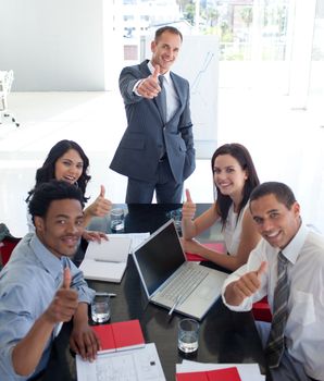 Happy business people in a meeting with thumbs up