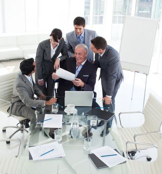 Smiling business people looking at a contract in a meeting