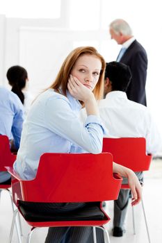 Young businesswoman bored at a conference with her colleagues