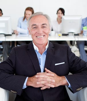 Portrait of a Smiling senior manager with his team in the background