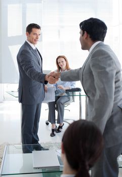 Multi-ethnic businessmen shaking hands in an office