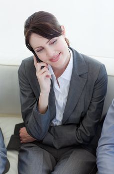 Smiling businesswoman on phone while waiting for a job interview in an office
