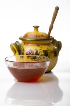 Mug full of honey on white background