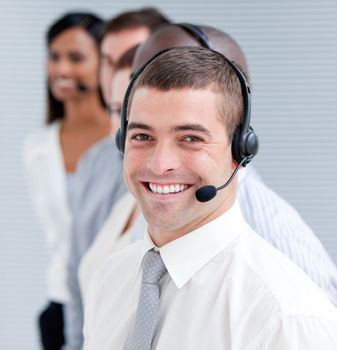 Cheerful customer service representatives with headset on standing in a line