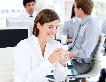 Smiling businesswoman holding a cup of coffee in the office
