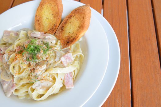 Italian food ,Tagliatelle with Ham and Cheese served on the wooden table