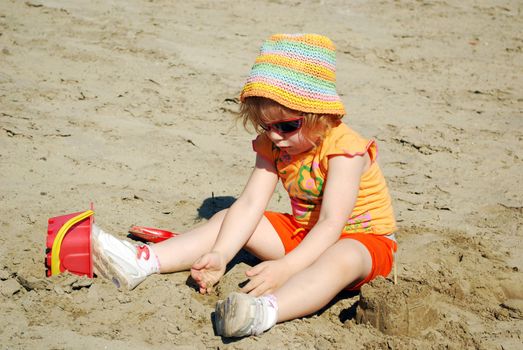 Beauty little girl playing in the sand