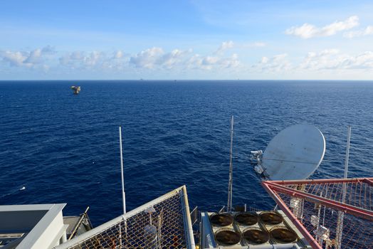 The satellite dish is set on the oil rig platfrom