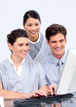 Multi-etnic business people working at a computer in a company
