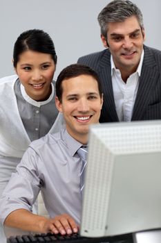 Diverse business partners working together at a computer