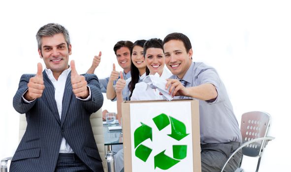 Cheerful business people showing the concept of recycling against a white background