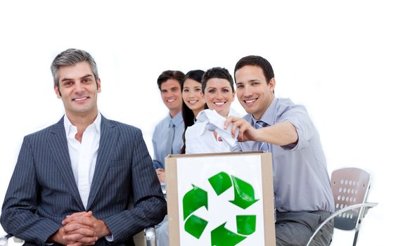 Confident business people showing the concept of recycling against a white background