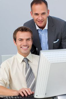 Attractive manager checking his employee's work in the office