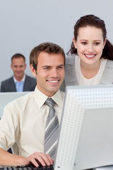 Smiling business partners working together at a computer in the office