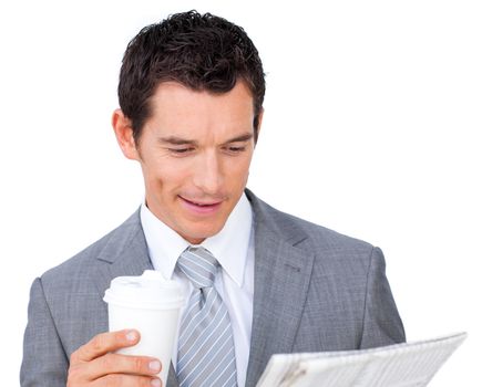 Attractive businessman holding a drinking cup and reading a newspaper