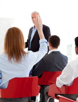 Businesswoman raising her hand up at a conference. Business concept.