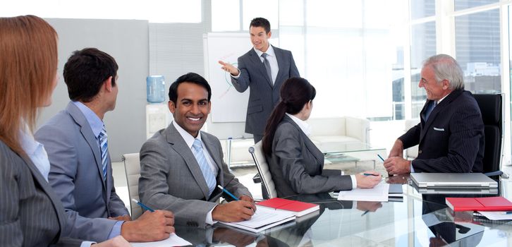 Businessman reporting sales figures to his team in the office