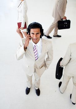 Attractive businessman on phone smiling at the camera in a business building