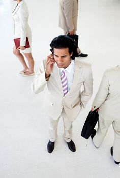 Attractive businessman on phone in a business building. Business concept.