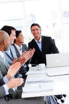 Team of successful business people clapping in a meeting