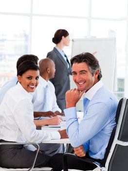 A diverse business group at a meeting smiling at the camera