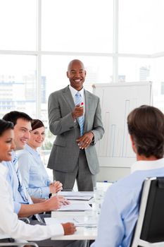 Confident Afro-American businessman discussing with his team in a presentation