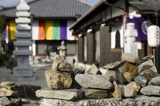 Small stones on the wall in front of a small japanese temple