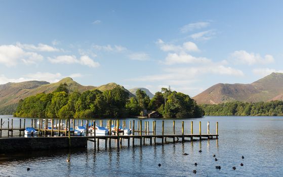 Piers and boats on edge of Derwentwater in English Lake District in early morning