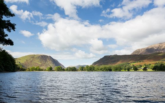 Mountains reflect into Buttermere calm lake in English Lake District