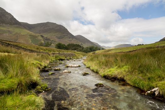 Rocky river leads to Buttermere over Honister Pass in English lake District