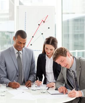 Concentrated business people working together sitting around a conference table 