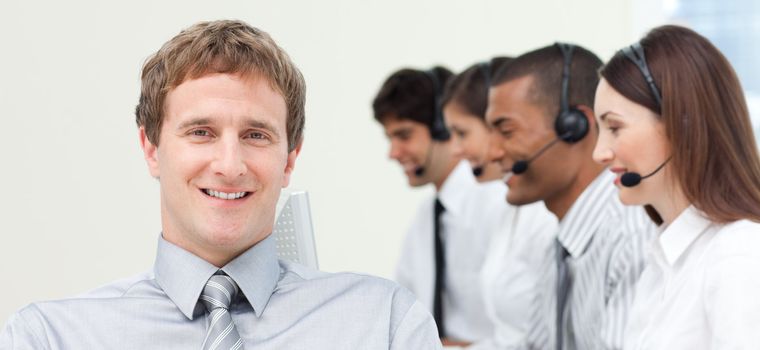 Young manager in front of his team in a call center