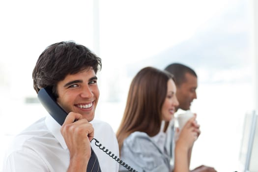Smiling businessman talking on phone in the office