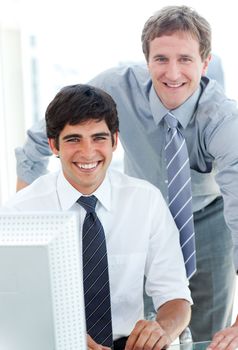 Two male executives working at a computer in the office