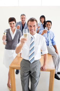 Multi-ethnic business people toasting with Champagne in the office