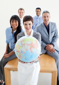 Smiling business team holding a terrestrial globe. Business concept.