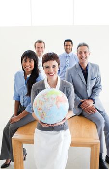 Multi-ethnic business people holding a terrestrial globe in the office 