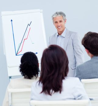 Mature businessman doing a presentation to her team