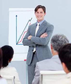 Confident businessman reporting sales figures to his team 