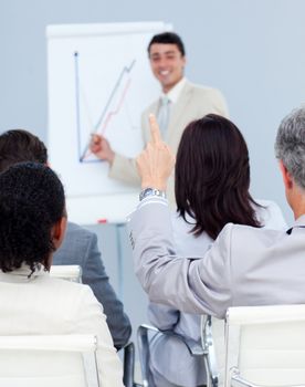 Senior businessman asking a question at a presentation with his colleagues