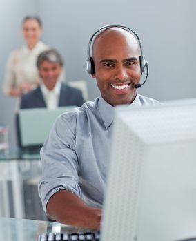 Confident  businessman with headset on working at a computer in the office