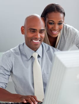 Confident business partners working at a computer together in the office