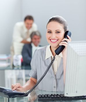 Charismatic businesswoman on phone working at a computer in the office