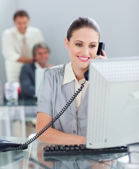 Confident businesswoman on phone working at a computer in the office
