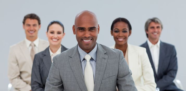 Charismatic Ethnic businessman with his team smiling at the camera