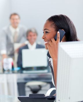 Smiling businesswoman on phone at her desk in the office