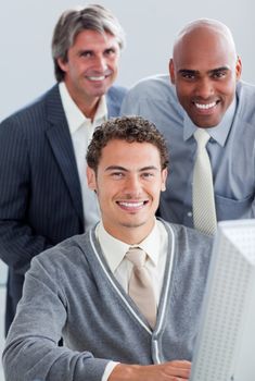 Charismatic business partners working at a computer in the office