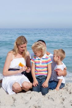 Attentive mother holding sunscreen at the beach with her family