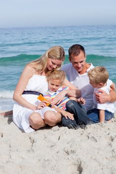 Smiling mother with her family holding sunscreen at the beach 